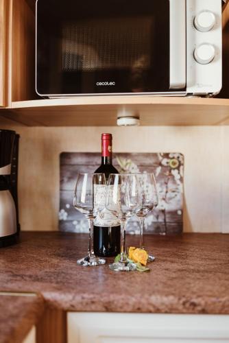 a bottle of wine and two wine glasses on a counter at Villa Hexengericht in Thale
