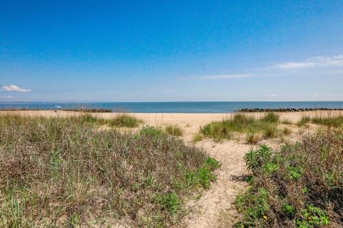 ein Sandstrand mit dem Meer im Hintergrund in der Unterkunft Sojourn Dune Cottage Beach Front Bliss 3 BR 3 BA in Norfolk
