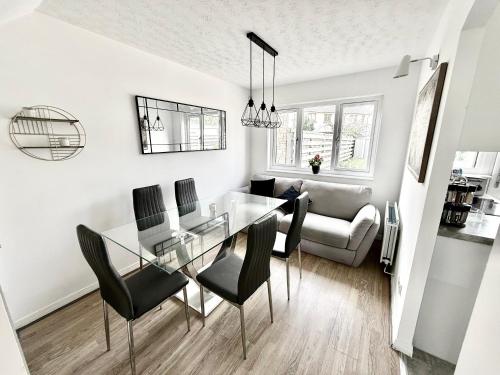 a dining room and living room with a glass table and chairs at Kings Meadows Luxury Home - Free Parking and SuperFast WiFi in Edinburgh