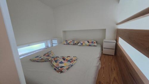a small white bedroom with a bed with two pillows at Top privacy Eco Villa of 2023 @ TEG hill Tirana in Tirana