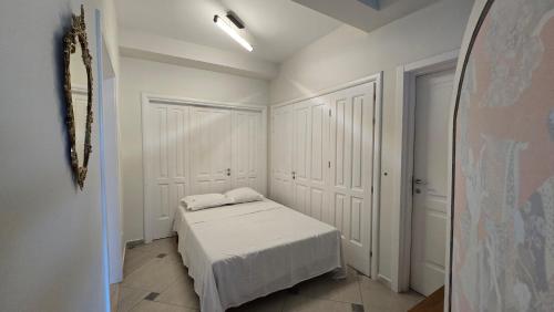 a white bedroom with a bed and a mirror at Top privacy Eco Villa of 2023 @ TEG hill Tirana in Tirana