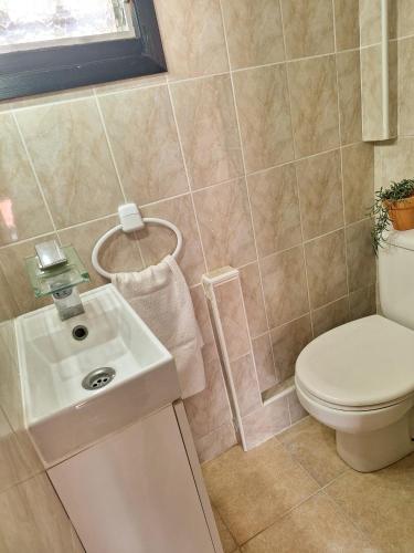 a bathroom with a toilet and a sink at Villa Nevada - Espacioso Chalet con Piscina Privada y Salita de Cine in Port de Pollensa