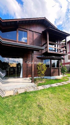 una grande casa in legno con un prato di fronte di Chalé nas montanhas a Domingos Martins