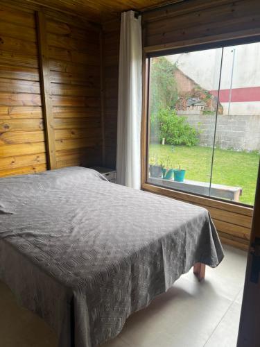 una camera da letto con un letto e una grande finestra di Chalé nas montanhas a Domingos Martins