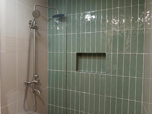 a bathroom with a shower with green tile at Buena Casa Hotel in Olongapo