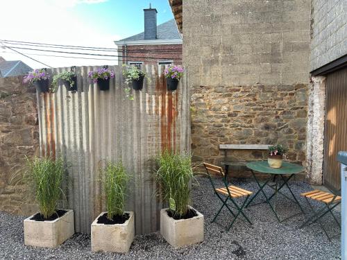 a patio with two chairs and a table with plants at STH1 - Cachette en centre-ville in Saint-Hubert