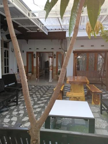 a patio with tables and a palm tree at Touchsmart in Lemahabang