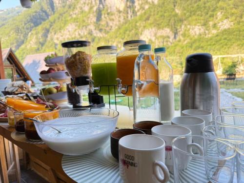 a table with cups and other items on it at Thethi Camping Villas in Theth