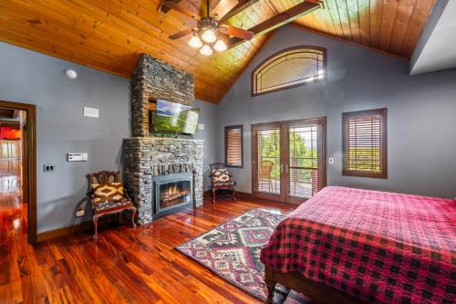 a bedroom with a bed and a stone fireplace at The King Of The Mountain - 6617 Sq Ft sleeps 22 amazing mountain views, Private Indoor Pool in Sevierville