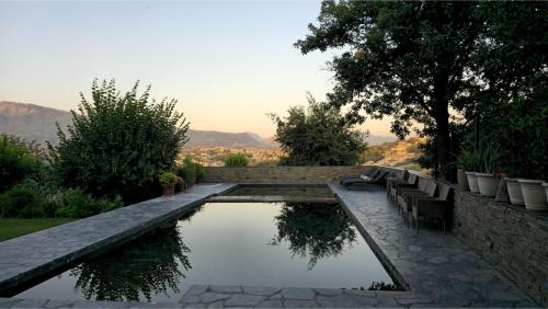 a pool of water with chairs and trees and mountains at Top privacy Eco Villa of 2023 @ TEG hill Tirana in Tirana
