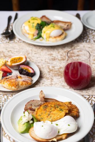 a table with three plates of food and a glass of wine at Girraween Country Inn in Ballandean