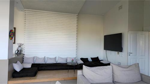 a living room with a couch and a large window at Top privacy Eco Villa of 2023 @ TEG hill Tirana in Tirana