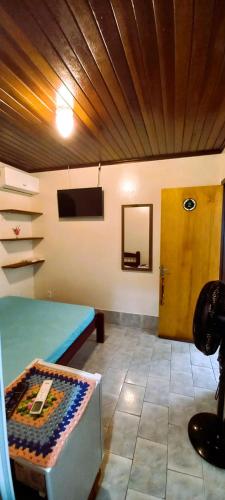 a room with a blue table and a wooden ceiling at Pousada do Arthur in Ilha do Mel