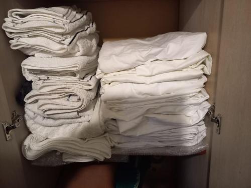 ein Stapel gefalteter weißer Kleidung in einem Schrank in der Unterkunft America in San Miguel de Tucumán