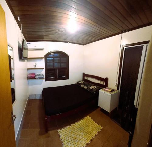 a small room with a bed and a window at Pousada do Arthur in Ilha do Mel