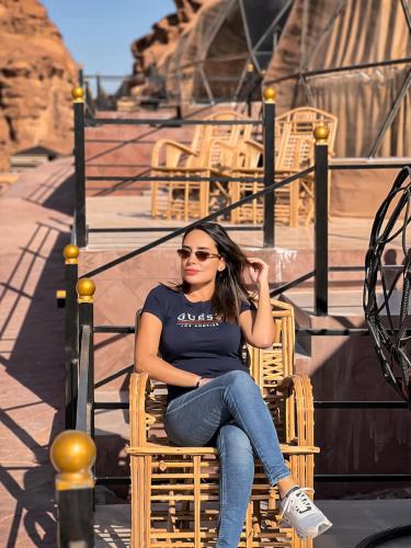 a young woman sitting in a chair in a chair at RUM WINGS BUBBLES lUXURY CAMP in Wadi Rum
