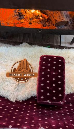 a sign that says desert wings next to a rug at RUM WINGS BUBBLES lUXURY CAMP in Wadi Rum