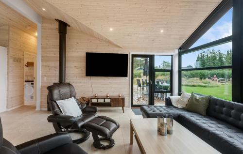a living room with a couch and a tv at 5 Bedroom Cozy Home In Væggerløse in Marielyst