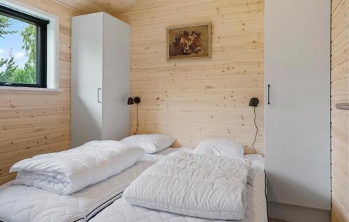 two beds in a room with wooden walls at 5 Bedroom Cozy Home In Væggerløse in Marielyst