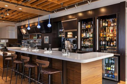 a bar in a restaurant with bar stools at Courtyard by Marriott Baldwin Park in Baldwin Park