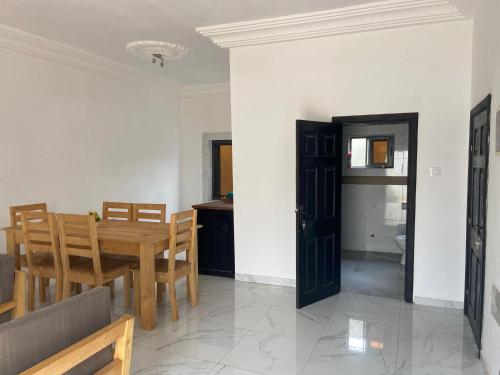 a dining room and kitchen with a table and chairs at Guest House Abomey Calavi Ahossougbéta in Abomey-Calavi
