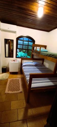 a bedroom with two bunk beds and a window at Pousada do Arthur in Ilha do Mel