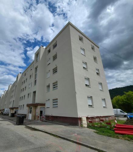 a large white building on the side of a street at Apt spacieux 3ch proches campus in Saint-Martin-dʼHères
