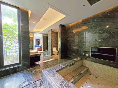 a bathroom with a tub and a large stone wall at The Castle Ballet Taichung A Boutique Hotel in Taichung