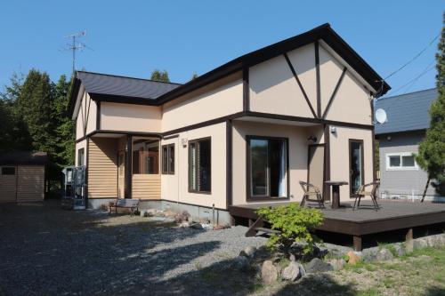 a tiny house with a porch and a deck at 草枕 -kusamakura- private stay in Tomakomai