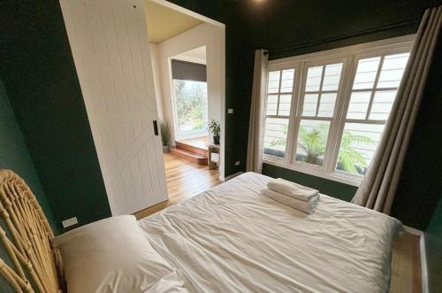 a bedroom with a white bed and a window at Phillip Island Coastal Cabins in Sunderland Bay