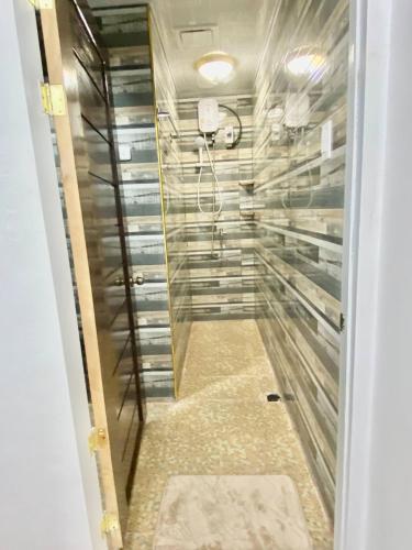 a walk in shower with a glass door at Lens Staycation 3BDR-2BR-Downstairs ,NetflixWifi in Panabo