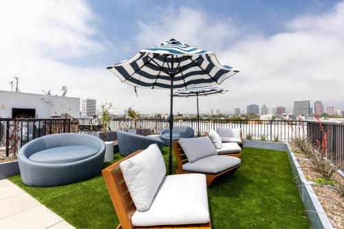 a patio with chairs and an umbrella on a roof at Westwood Penthouse 3 Bedroom 2 Bath w Gym, Balcony, Parking in Los Angeles