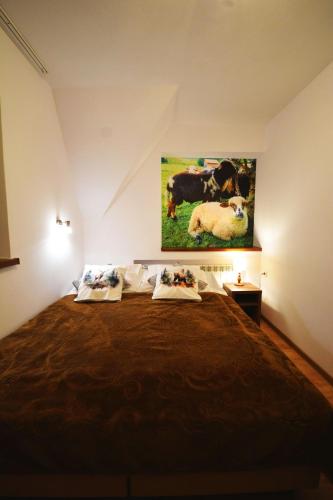 a bedroom with a bed with a painting on the wall at Apartamenty Willa Anna in Poronin