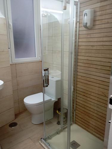 a bathroom with a toilet and a glass shower at EL BALCÓN DE LA PLAZA. in Arévalo