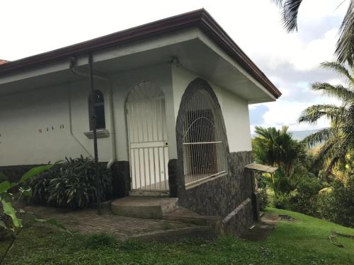 a small white house with a gate in the yard at La Serenidad in Tronadora