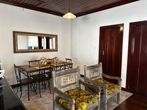 a dining room with chairs and a table and a mirror at Casa Para-ti in Paraty