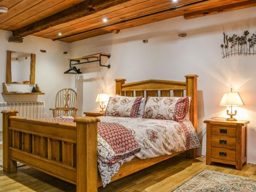 ein Schlafzimmer mit einem Holzbett und zwei Lampen in der Unterkunft The Bothy - Cottage in Dearham