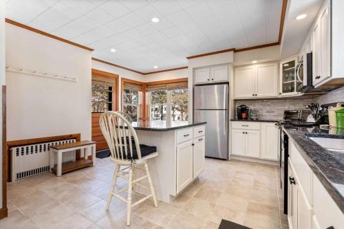a kitchen with white cabinets and a chair in it at Beachfront Just steps and you're on the beach in Saco
