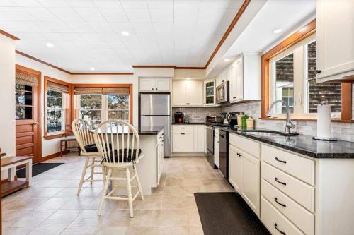 a kitchen with white cabinets and a table and chairs at Beachfront Just steps and you're on the beach in Saco
