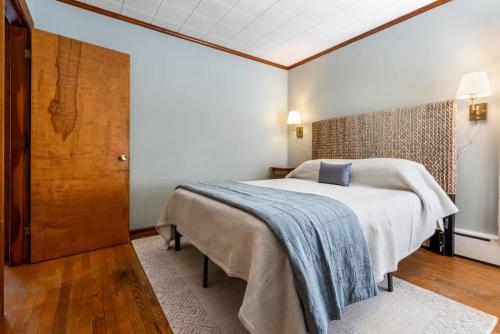 a bedroom with a large bed and a wooden door at Beachfront Just steps and you're on the beach in Saco
