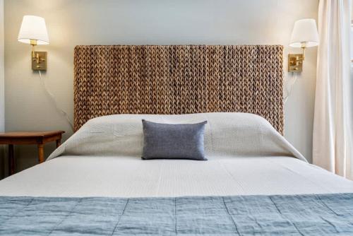 a bedroom with a large bed with a blue pillow at Beachfront Just steps and you're on the beach in Saco