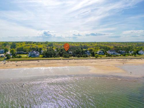 an orange kite flying over a sandy beach at Beachfront Just steps and you're on the beach in Saco