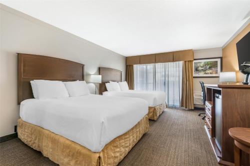 a hotel room with two beds and a television at Best Western The Westerly Hotel in Courtenay
