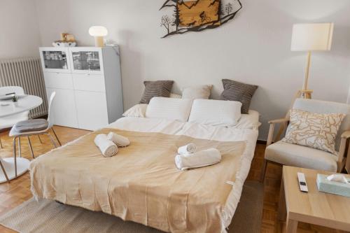 Un dormitorio con una cama grande con toallas. en Crans-Montana - studio - 2 personnes - balcon avec superbe vue, en Crans-Montana