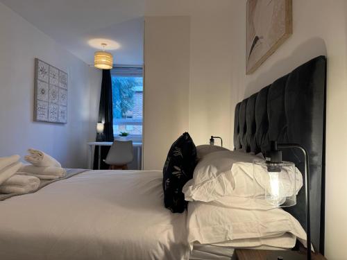 a bedroom with a large white bed with a black headboard at Two Bedroom Flat for Six Guests in London