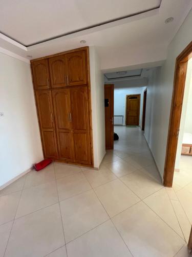 an empty room with wooden cabinets and a tile floor at Ain Taya residency in 'Aïn Taya
