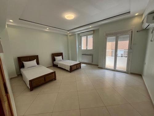 a large room with two beds and a window at Ain Taya residency in 'Aïn Taya