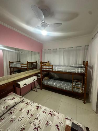 a bedroom with two beds and a ceiling fan at Hospedagem Marceli in Paraty