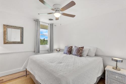 a white bedroom with a bed and a ceiling fan at 2008 - Sound Sea Secret in Sanderling