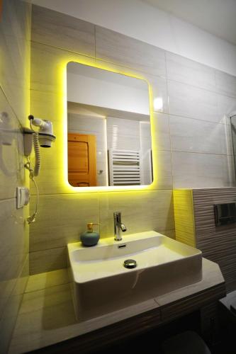 a bathroom with a sink and a mirror at Apartamenty Willa Anna in Poronin